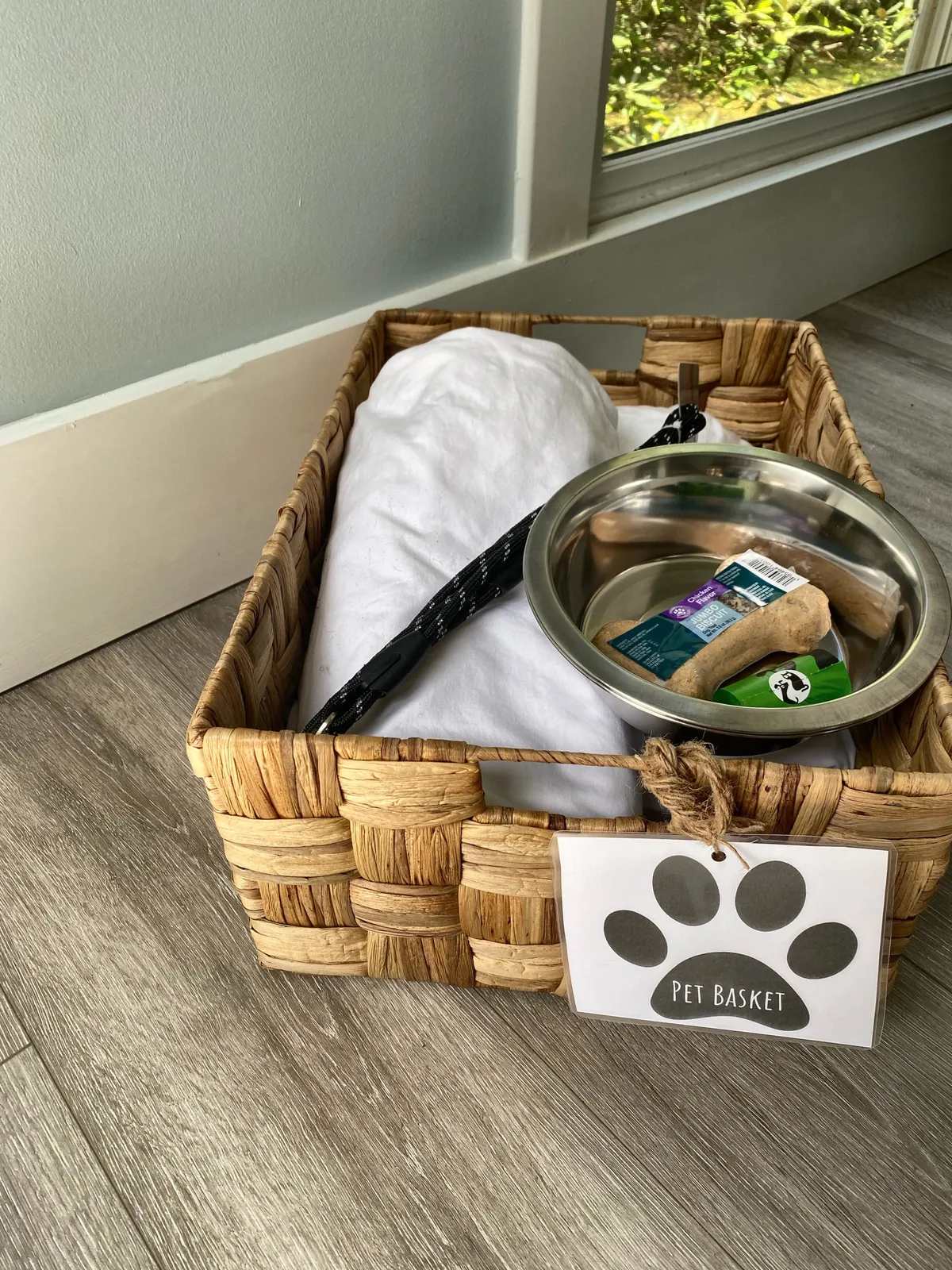 A welcoming nook complete with a woven basket, pet bowl, treats, and a cozy blanket—an inviting setup for guests traveling with pets.
