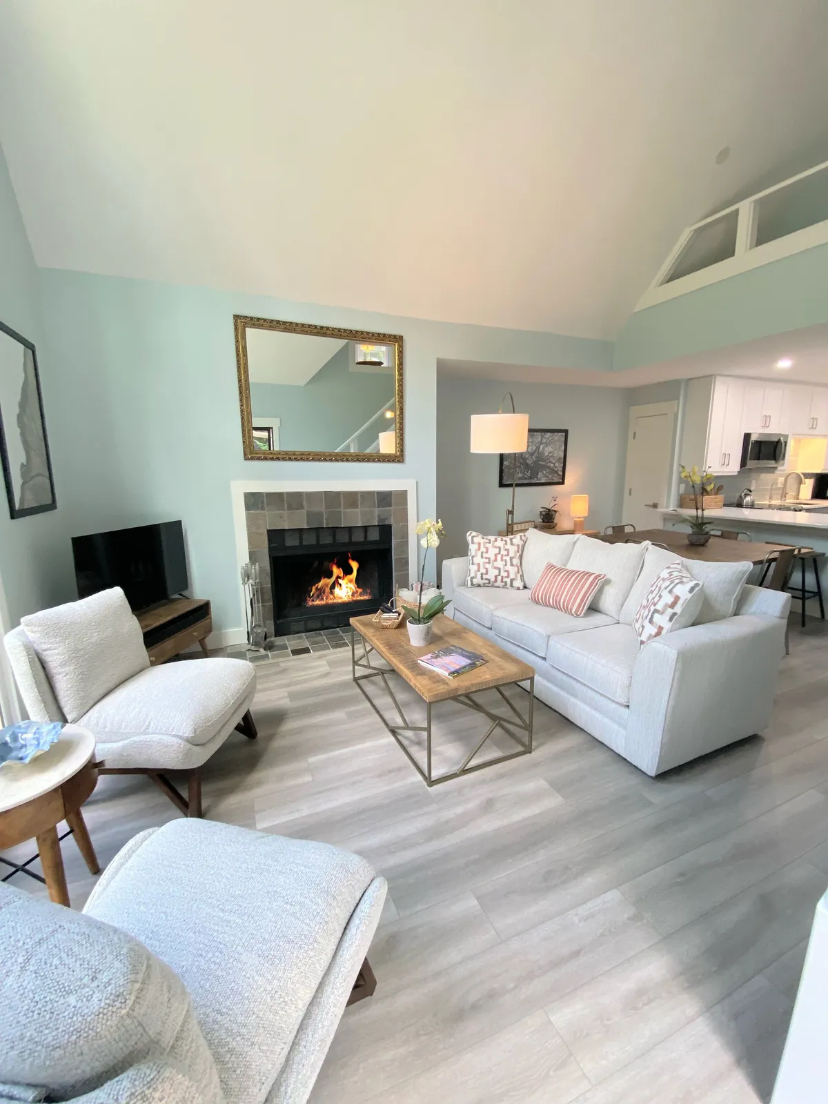 A welcoming living area featuring a fireplace, plush sofa, coffee table, and thoughtfully chosen artwork. The room radiates coziness, suggesting an inviting space for evening relaxation or intimate conversations after exploring nearby attractions.